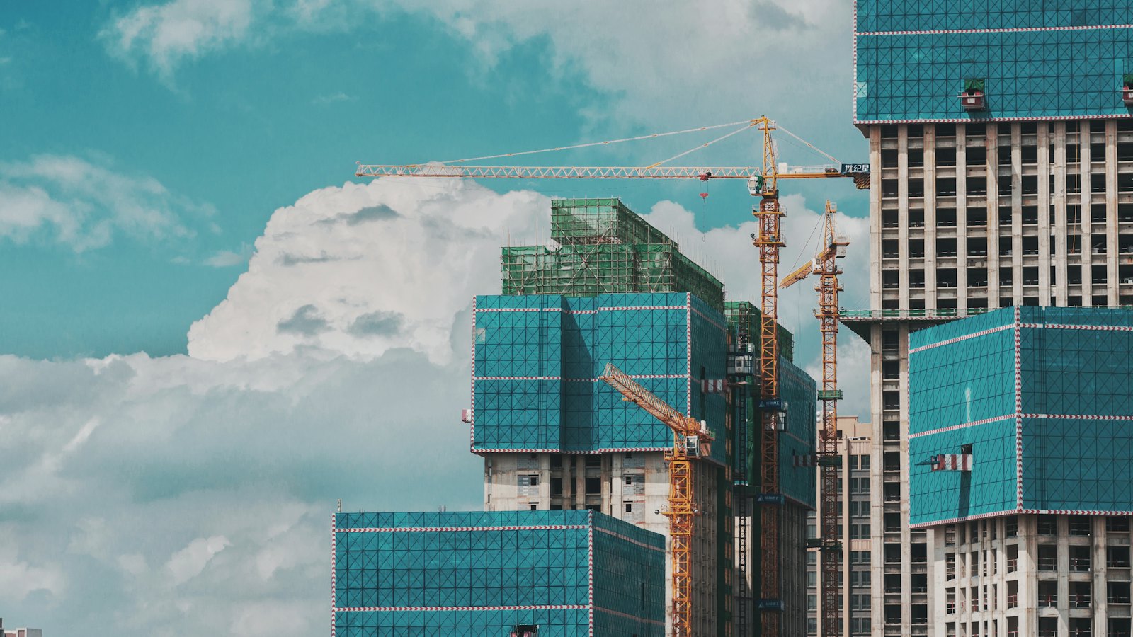 Tower cranes beside high-rise buildings under construction